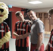 Bayer-04-Maskottchen Brian The Lion mit Glas- und Gebäudereinigern der Weber Gruppe sowie zwei Spielern von Bayer 04 Leverkusen.