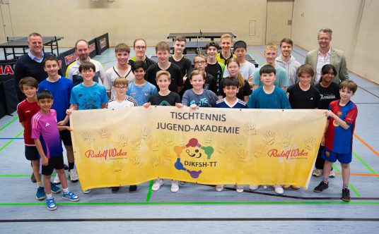 Die Nachwuchsspieler*innen präsentieren das Banner.