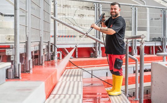 Ein Gebäudereiniger von Rudolf Weber Gebäudedienste im Einsatz mit dem Hochdruckreiniger in der BayArena.